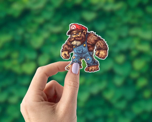 A hand holding a Bigfoot sticker that looks like Mario